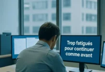 Employé assis à son bureau dans un espace de travail lumineux et végétalisé, entouré d’écrans, l’air légèrement fatigué mais serein, symbolisant la fatigue moderne au travail dans une ambiance apaisante.